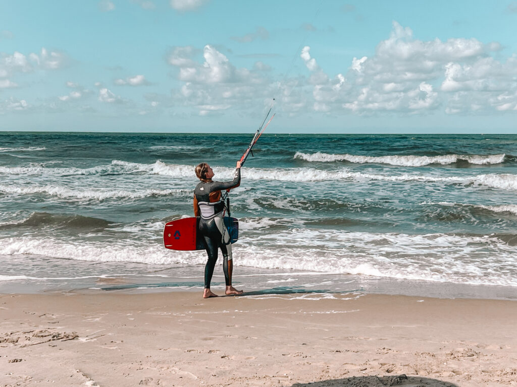 Dutch girl holding a kite in the air on the dutch beach in Texel